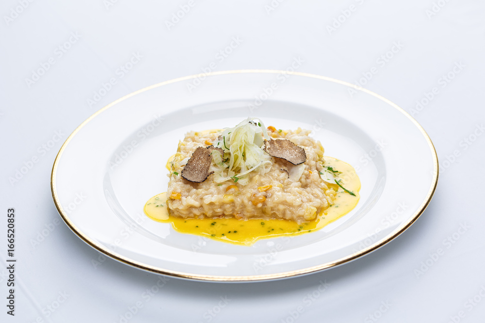 Risotto with truffles and corn sauce in white plate Risotto with truffles and corn sauce in white plate