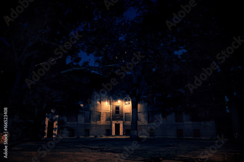 An abandoned city public housing project building with boarded up windows at the historic Lathrop Homes in Chicago at night.