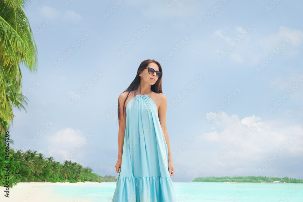 Beautiful young woman on sea beach at tropical resort