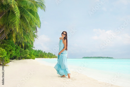Beautiful young woman on sea beach at tropical resort