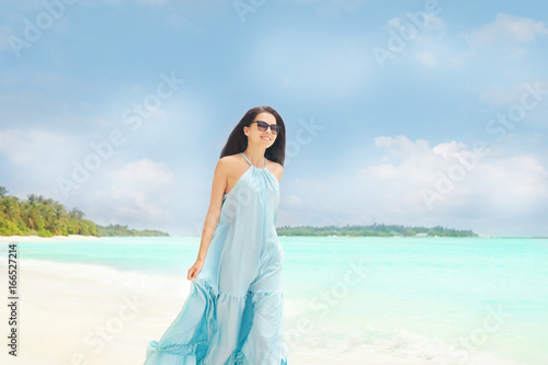 Beautiful young woman on sea beach at resort