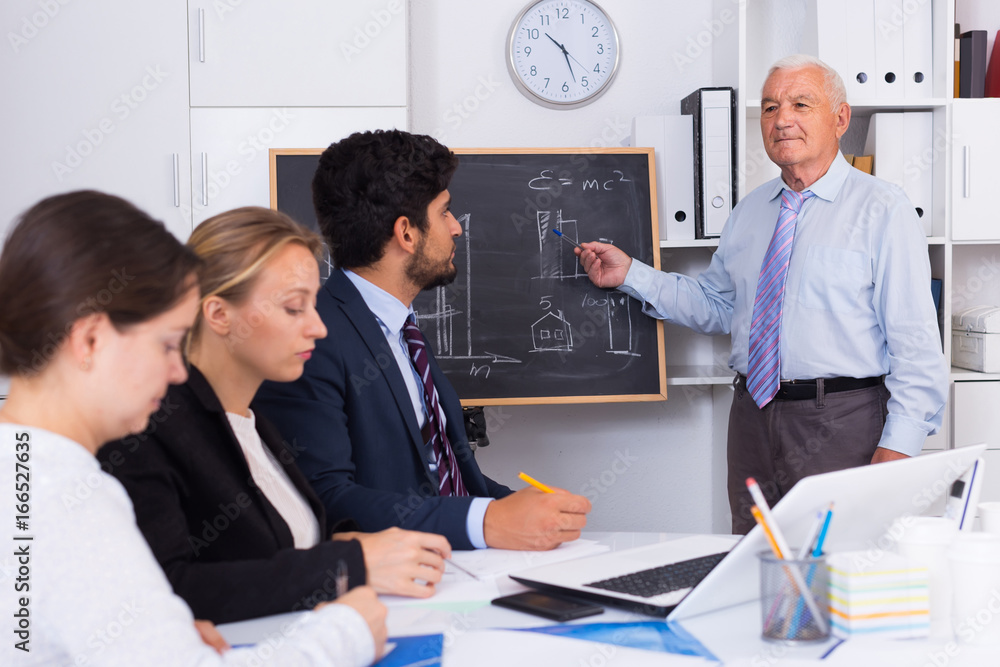 Fototapeta premium Old boss is introducing subordinates in project on the meeting