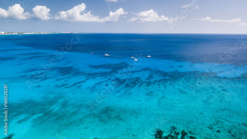 Dive boats over a large shipwreck in clear, blue, tropical waters