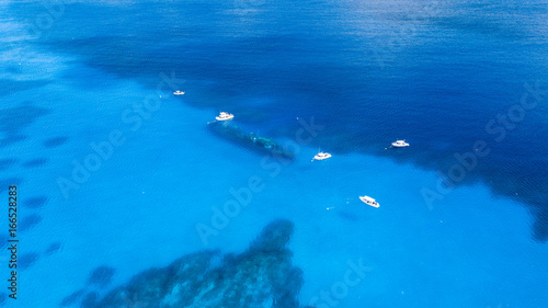 Dive boats over a large shipwreck in clear, blue, tropical waters
