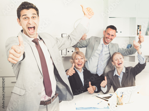 Smiling businessman and team delighted with achievements photo