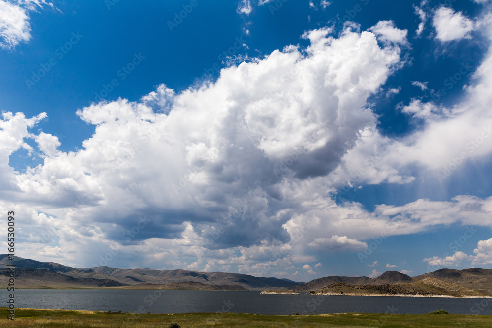 Fototapeta premium Cumulus Clouds and Blue Sky Over Lake