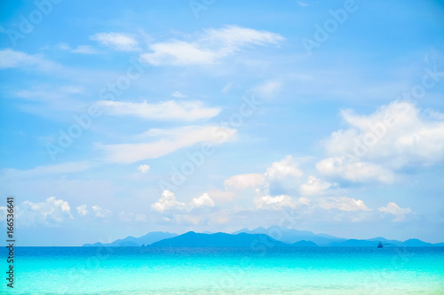 Beautiful white clouds on blue sky over calm sea with sunlight reflection, Tranquil sea harmony of calm water surface. Vibrant sea with clouds on horizon