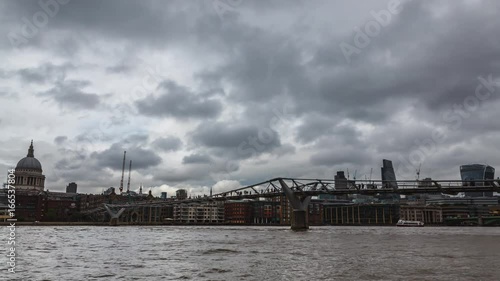 London Millennium Bridge Time-Lapse with St Paul's and the City in cloudy and rainy typical British weather. photo