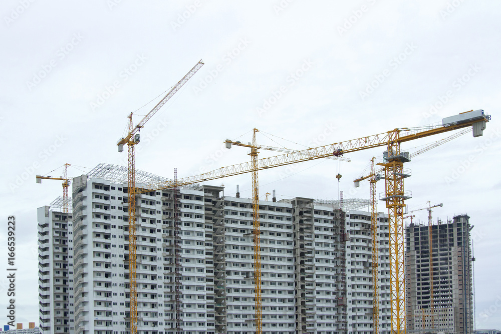 Several cranes are building a building with a white background. Several cranes are building a building with a white background.