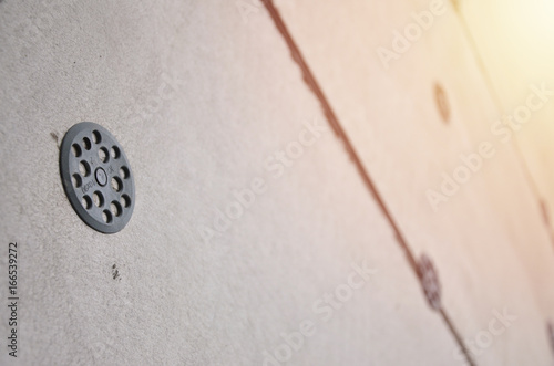 The texture of the wall, covered with gray foam polystyrene plates, which are reinforced with plastic umbrella dowels. Stage of wall insulation