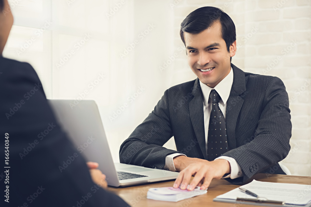 Sly tricky businessman giving money to his partner at working table
