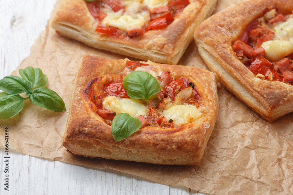 Open pies puff pastry with tomato, mozzarella, onion and Basil. Mini pizza. Selective focus