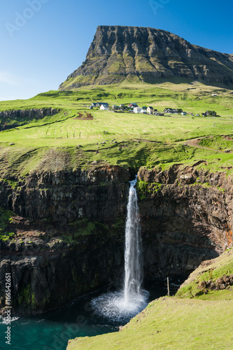 Wasserfall auf den Färöern mit dem Dorf Gasadalur im Hintergrund