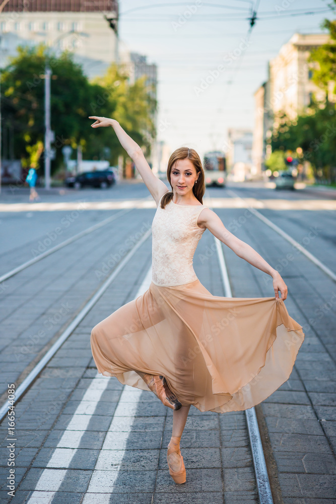 Obraz premium Ballerina in leotard and skirt and ballet shoes dancing on the street, jumps and bends