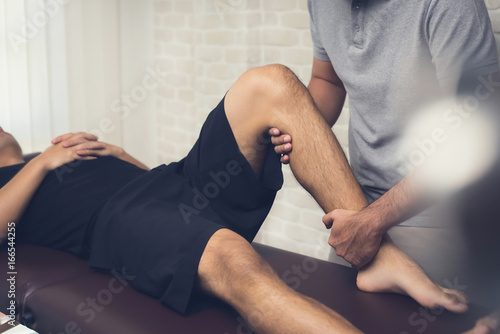 Physiotherapist treating athlete male patient photo