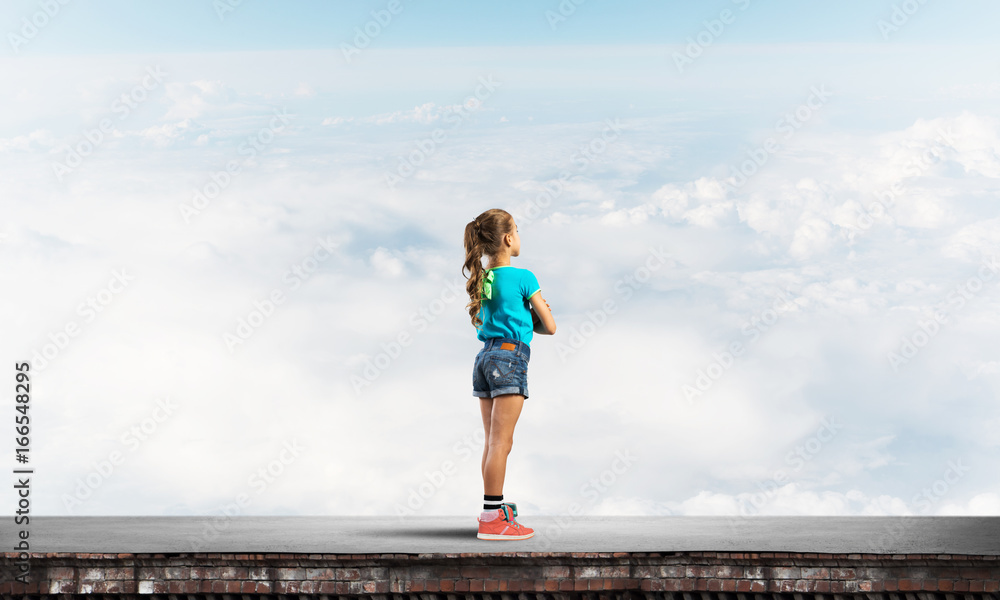 Concept of careless happy childhood with girl looking far away Concept of careless happy childhood with girl looking far away