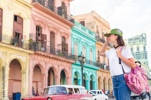 Young woman in popular area in old Havana, Cuba. Beautiful girl traveler background colorful houses in the city © travnikovstudio