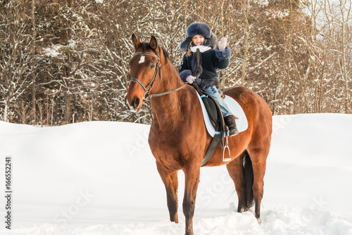 Small girl and horse in a winter