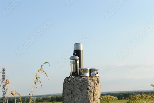 Alternative coffee brewing in a french press in nature. On the background of a clear blue sky photo