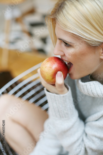 Young woman eating an apple. Close up portrait of young woman eating an apple.