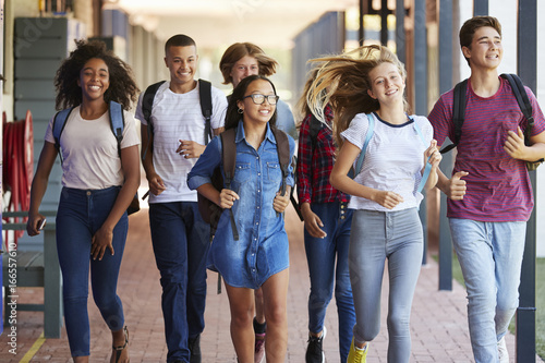 Teenager school kids running in high school hallway photo