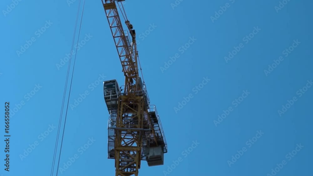 Construction Industry. Tower Crane Working Against Blue Sky Construction Industry. Tower Crane Working Against Blue Sky