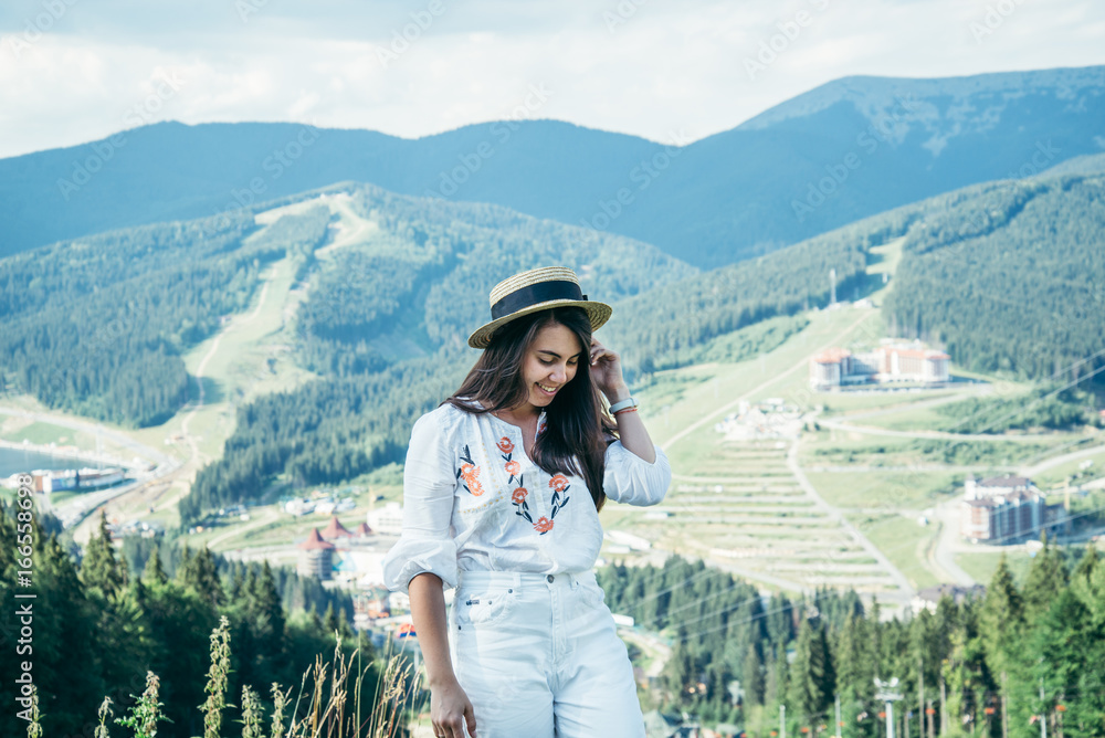 Naklejka premium young pretty woman walking by mountain peak