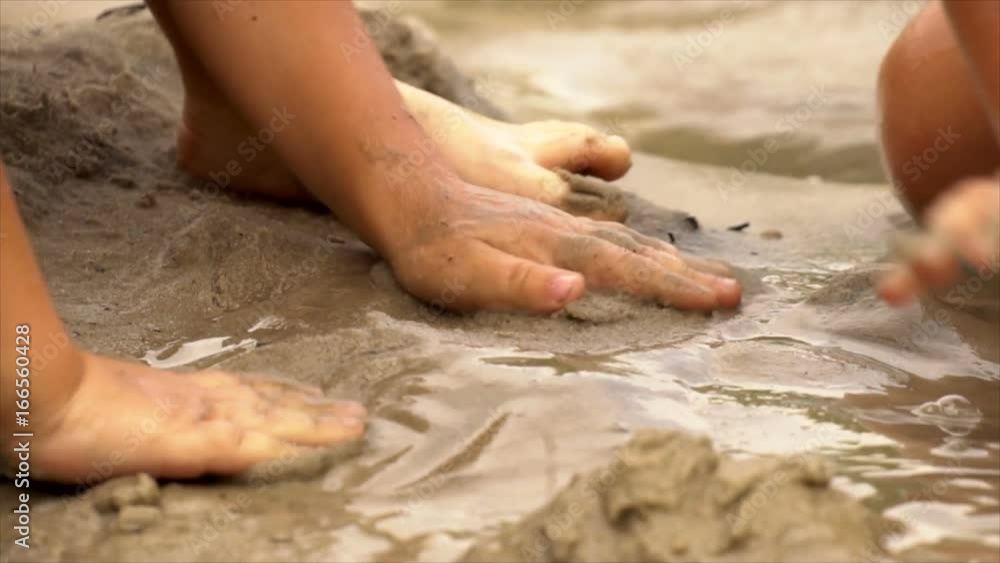 Children play in the sand on the beach in the summer. Slow motion Children play in the sand on the beach in the summer. Slow motion