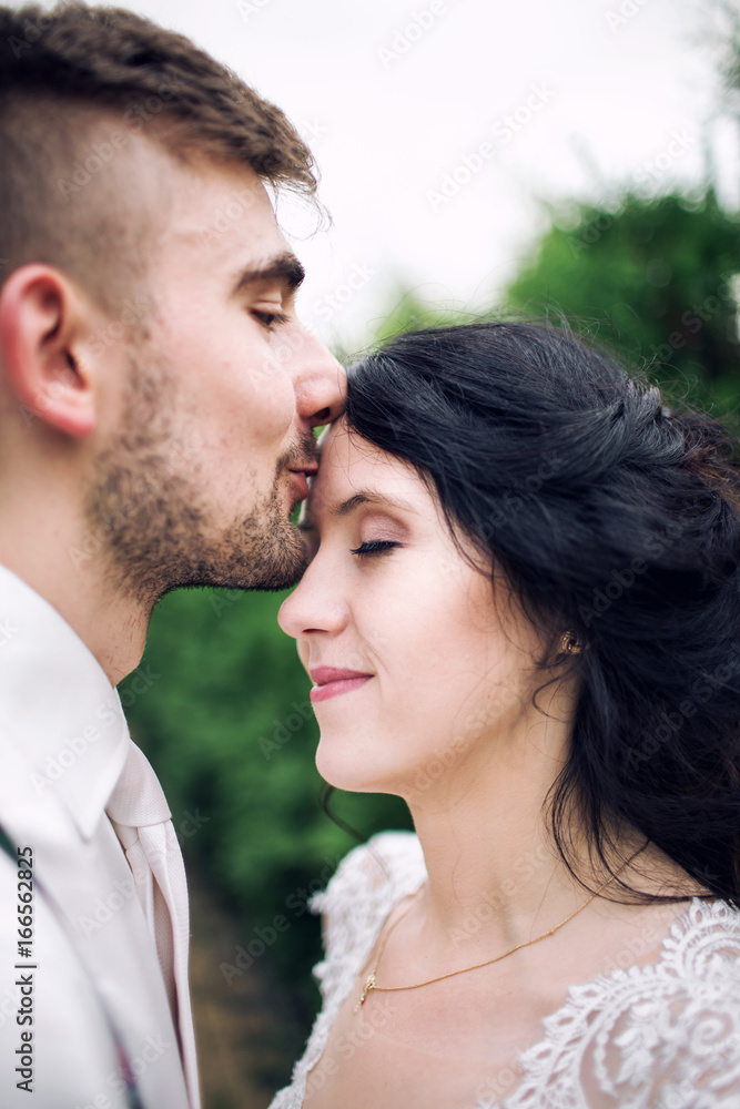 Young happy man kissing woman on the forehead Young happy man kissing woman on the forehead
