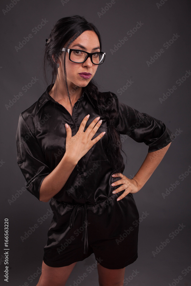 Young sexy woman portrait of a confident businesswoman showing by hands on a black background. Ideal for banners, registration forms, presentation, landings, presenting concept. Young sexy woman portrait of a confident businesswoman showing by hands on a black background. Ideal for banners, registration forms, presentation, landings, presenting concept.