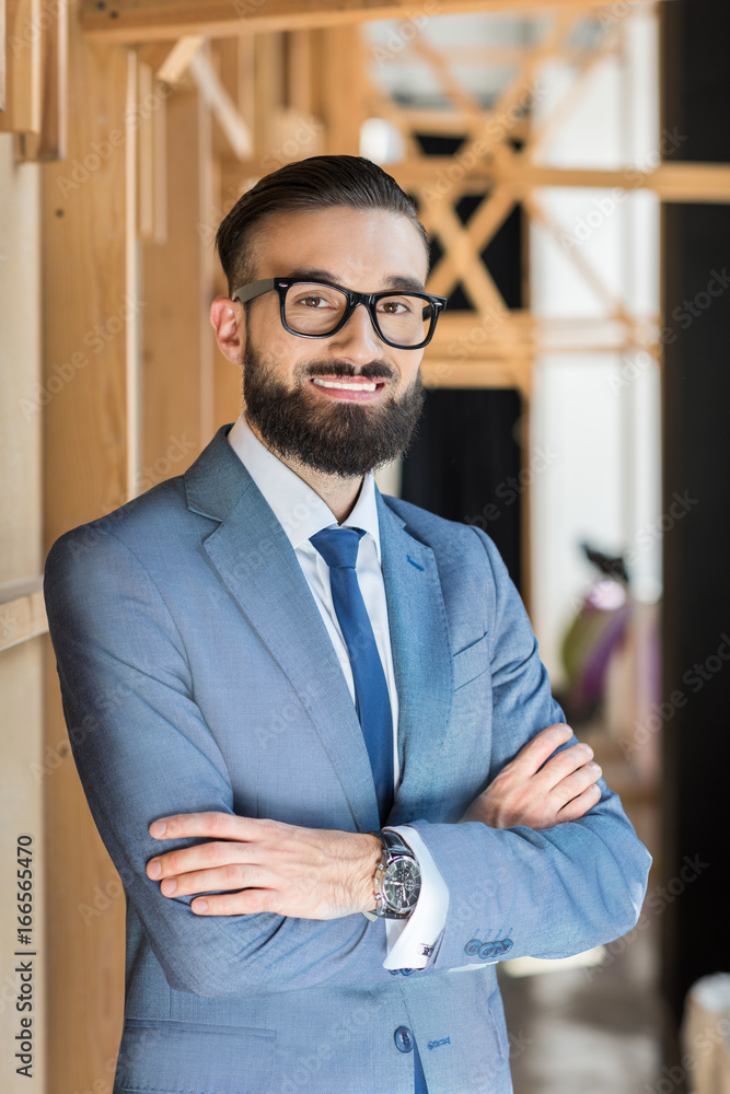 handsome businessman in grey suit with crossed arms looking at camera handsome businessman in grey suit with crossed arms looking at camera