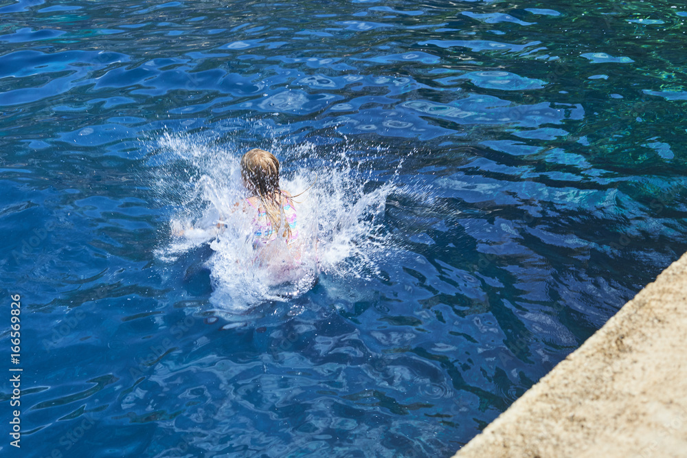 Obraz premium Happy child boy jumping into the blue sea
