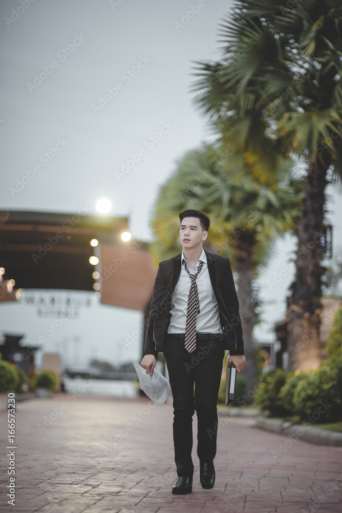 Tired or stressed businessman sitting on the walkway in the city after his work. Image of Stressed businessman concept, young caucasian businessman tired from work sitting at stairs, unemployment. Tired or stressed businessman sitting on the walkway in the city after his work. Image of Stressed businessman concept, young caucasian businessman tired from work sitting at stairs, unemployment.
