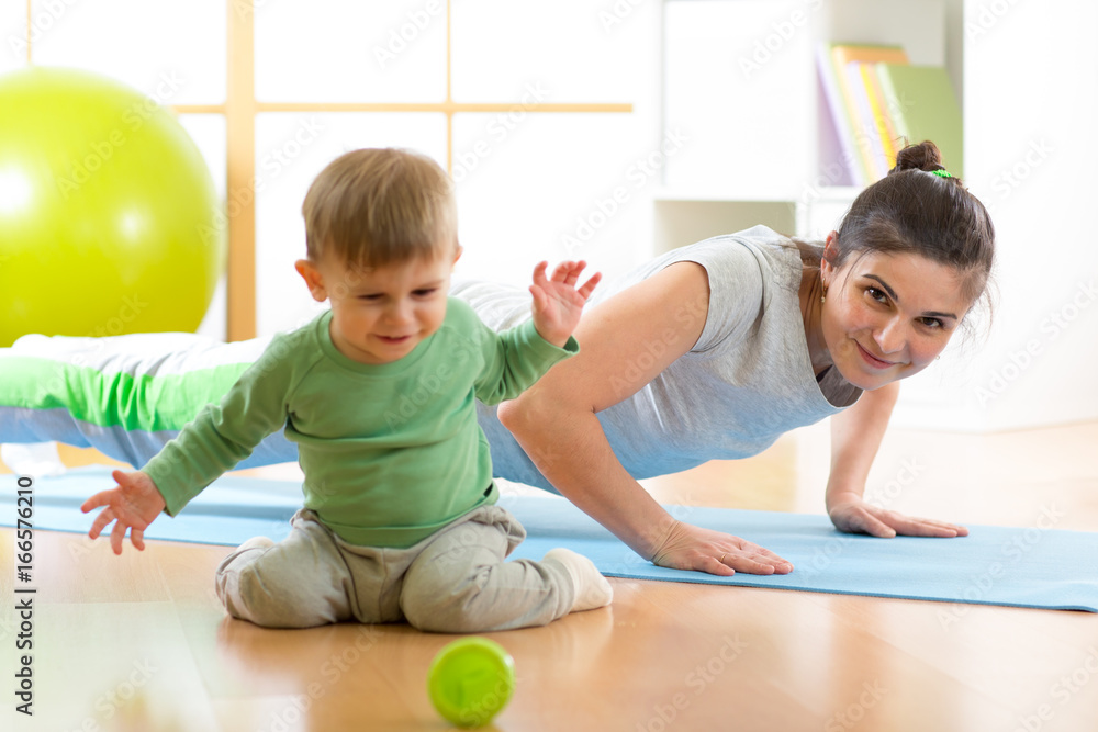 Fototapeta premium mother doing yoga or fitness exercises with baby