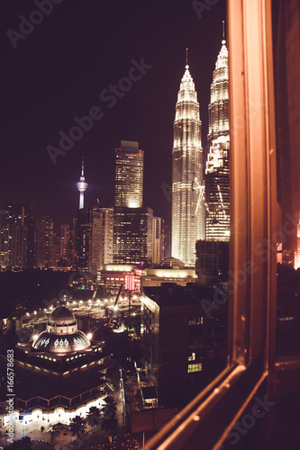 Spectacular night city view from office window. Kuala Lumpur famous skyscrapers  Malaysia. Business metropolis. Modern buildings. Luxurious travel.Urban cityscape. Metropolitan architecture. Nighttime