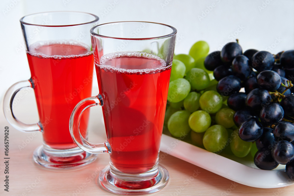 Two glasses of juice and black grapes Two glasses of juice and black grapes