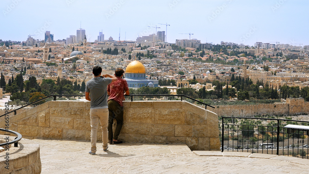 Tourist takes a photo and selfie against Jerusalem Old City view. Mount of Olives is a famous Holy Land place and it has a fantastic view to the Old Jerusalem