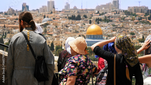 Fotografie The Christian orthodox guide shows the Jerusalem Old City view to the pilgrims and tourists from the Mount of Olives