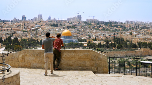Tourist takes a photo and selfie against Jerusalem Old City view. Mount of Olives is a famous Holy Land place and it has a fantastic view to the Old Jerusalem