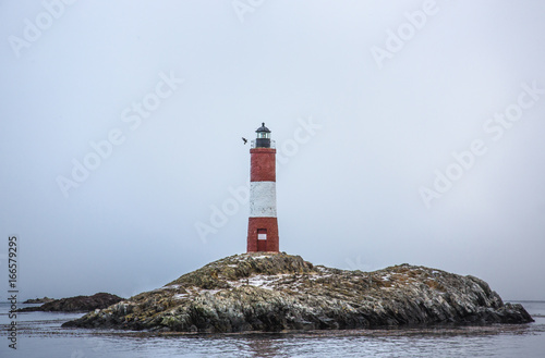 Lighthouse on rocky island photo