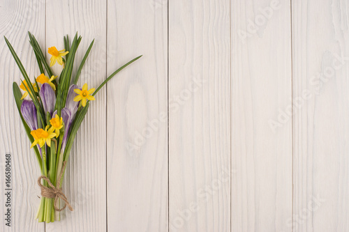 Fototapeta Naklejka Na Ścianę i Meble -  Daffodils and crocuses on the old white wooden table.