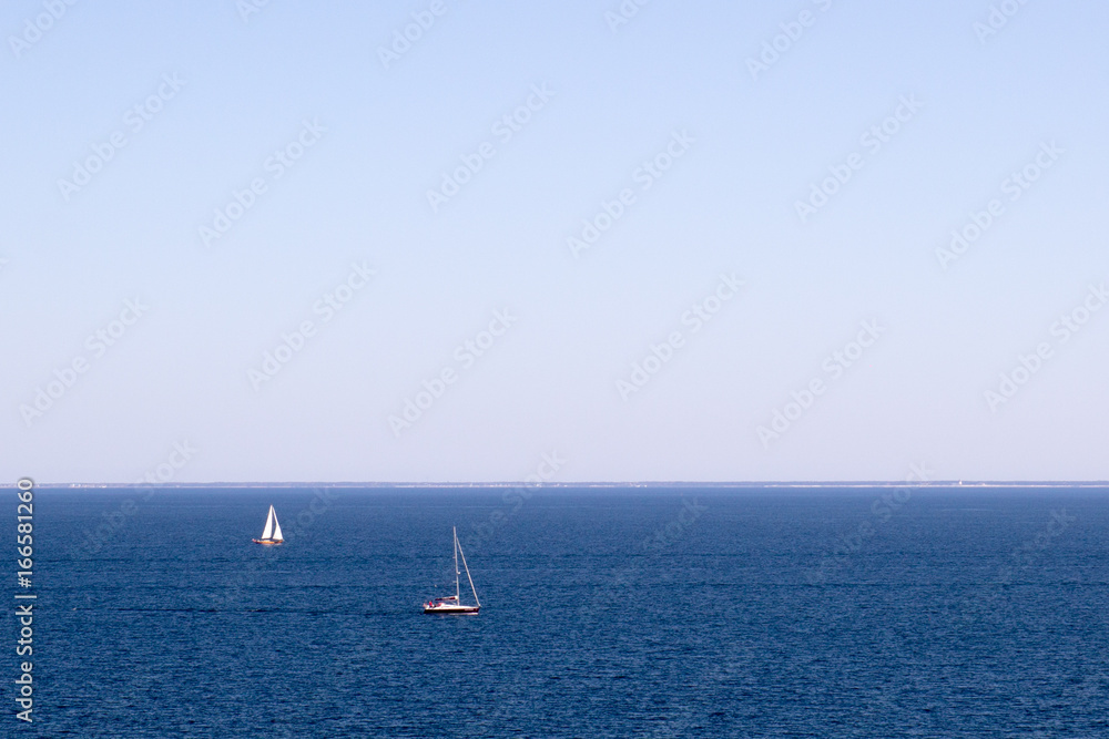 Two sailboats on a blue sea