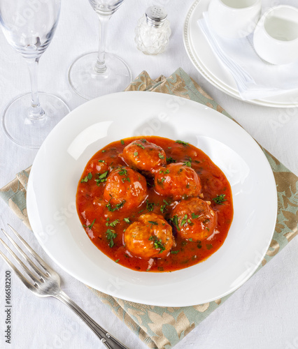 Tasty meatballs in tomato sauce with parsley.