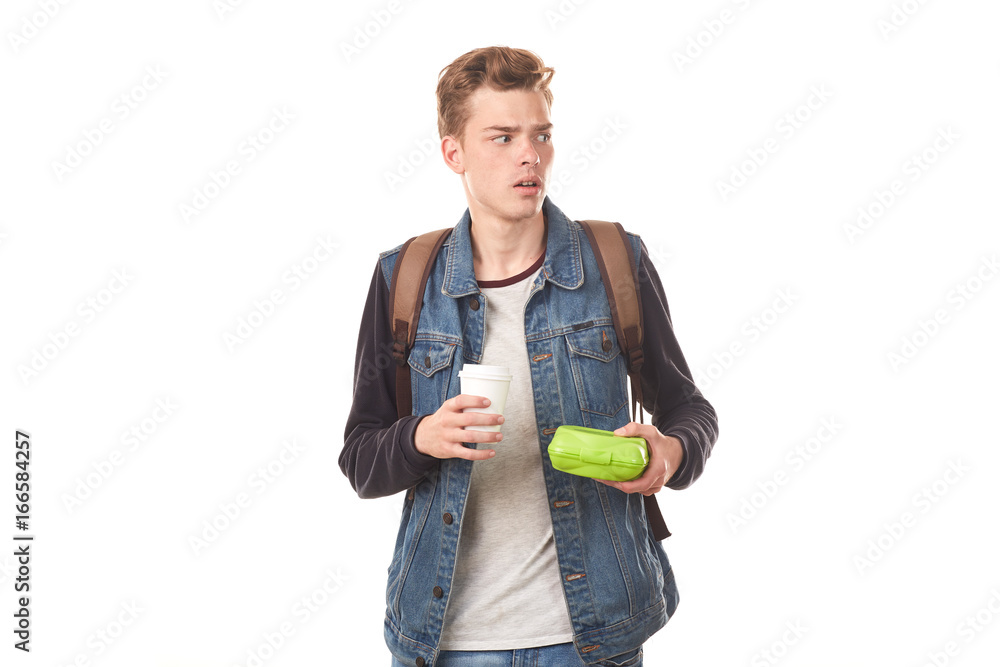 Portrait of schoolboy holding lunchbox and paper coffee cup Portrait of schoolboy holding lunchbox and paper coffee cup