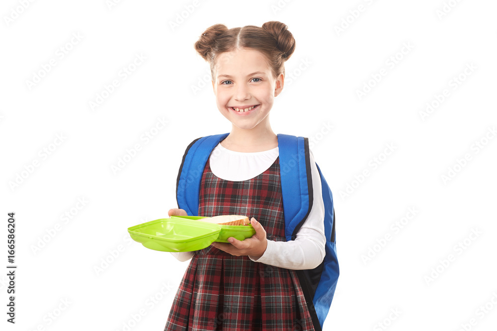 Portrait of cute girl in school uniform standing with lunchbox against white background Portrait of cute girl in school uniform standing with lunchbox against white background