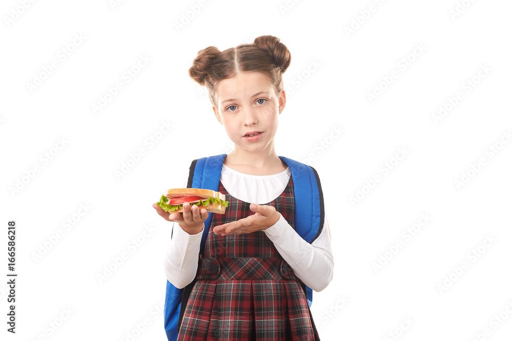 Portrait of cute girl in school uniform eating sandwich against white background Portrait of cute girl in school uniform eating sandwich against white background