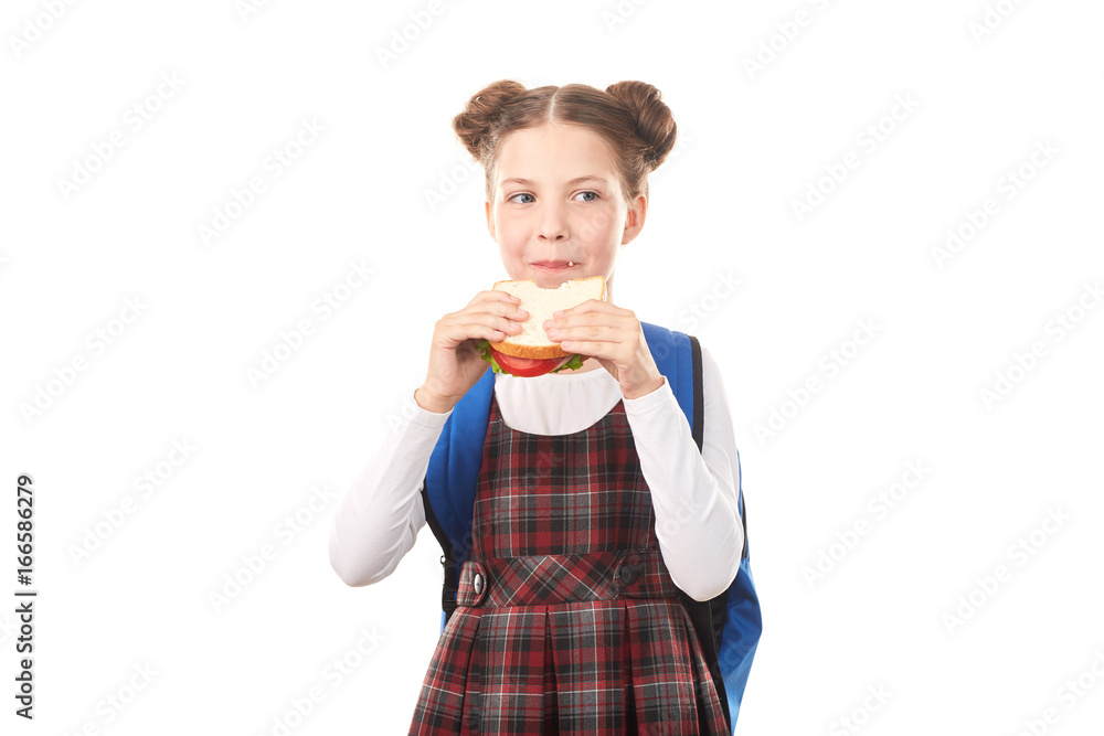Portrait of cute girl in school uniform eating sandwich against white background Portrait of cute girl in school uniform eating sandwich against white background