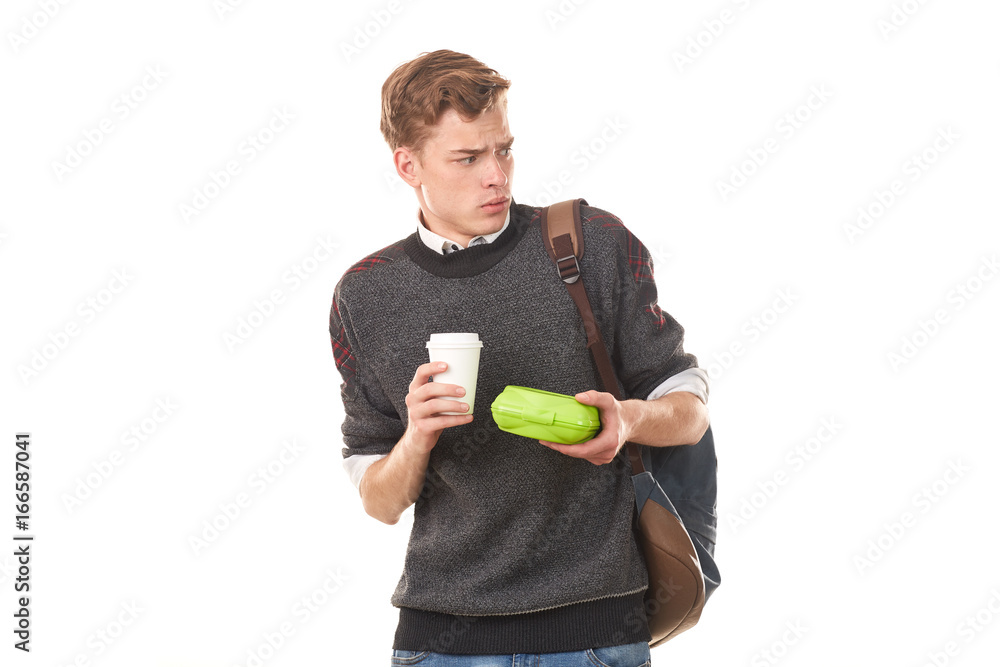 Handsome college boy holding lunchbox and paper cup of coffee Handsome college boy holding lunchbox and paper cup of coffee