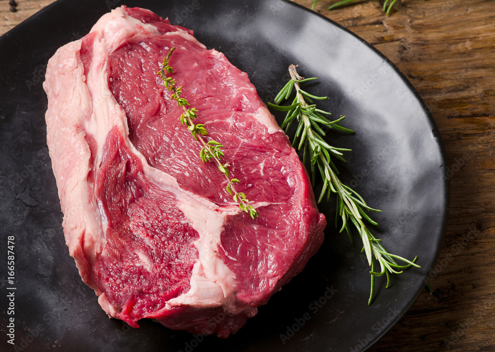 Raw meat Ribeye Steak with seasoning  on dark wooden background