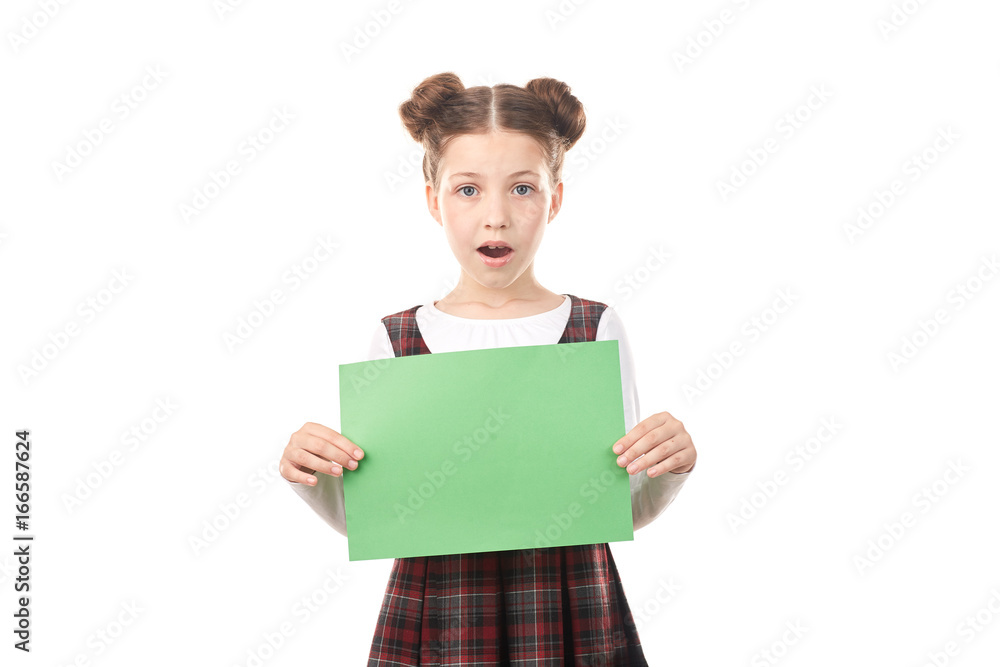 Portrait of surprised girl in school uniform holding blank paper against white background Portrait of surprised girl in school uniform holding blank paper against white background
